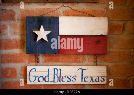 Un écriteau 'God Bless Texas' et un signe du Texas décorer un mur de brique à Lancaster, Dallas, Texas, United States. Banque D'Images