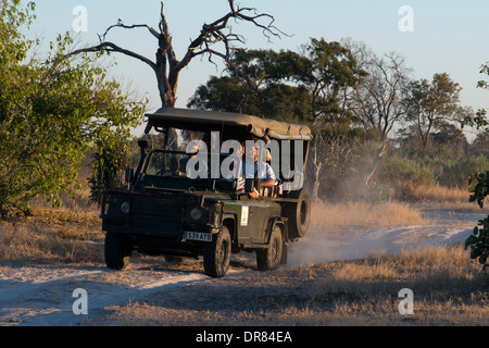 L'un des véhicules 4x4 Orient Express rend un arrêt en route au coucher du soleil pour faire un thé et regarder le coucher de soleil à côté d'un baobab Banque D'Images