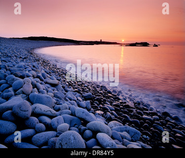 Guernesey. Fontenelle Bay. Pebble Beach Cove au coucher du soleil. Banque D'Images