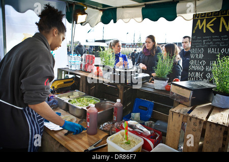 Marché de London food à Canary Wharf. La préparation et la vente du vendeur la nourriture grecque Halloumi attaches pour les clients d'attente. Banque D'Images