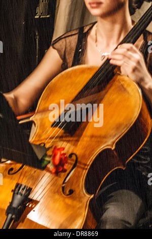 Musicien jeune femme chanter à la violoncelle sur la pluie. Métaphore de l'image. Banque D'Images