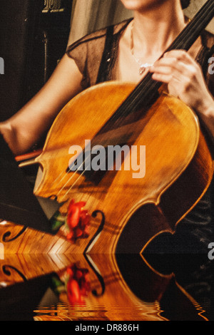 Musicien jeune femme chanter à la violoncelle sur l'eau. Métaphore de l'image. Banque D'Images