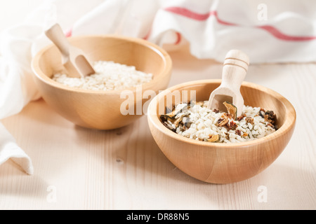 Mélange de légumes secs et de riz cru dans des bols en bois sur un fond clair Banque D'Images