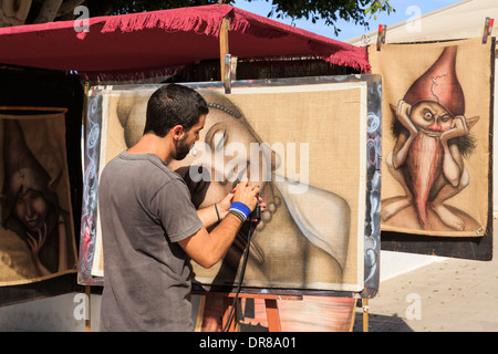 Jeune artiste de l'homme individuel au travail la peinture par pulvérisation Photo sur toile en dimanche street market dans Teguise Lanzarote Iles Canaries Espagne Banque D'Images