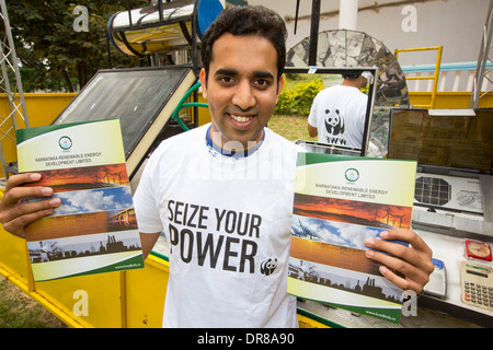 Un jeune homme portant un pouvoir saisir votre Tshirt, une campagne menée par le WWF pour promouvoir l'énergie renouvelable, à côté d'un camion Banque D'Images