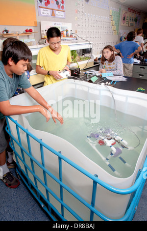 À l'aide d'un réservoir de laboratoire, multiracial middle school students in Mission Viejo, CA, tester l'engin télécommandé à distance) qu'ils ont construit dans leur classe de robotique. Banque D'Images