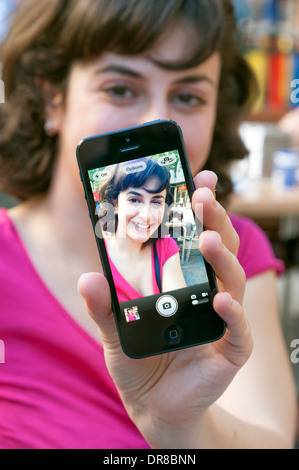 Jeune femme tenant un sur un iPhone d'Apple selfies Banque D'Images