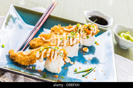 Thon ahi pané frit sur une boule de riz, arrosé de masago, mayonnaise et parsemé d'oignons verts et masago Banque D'Images