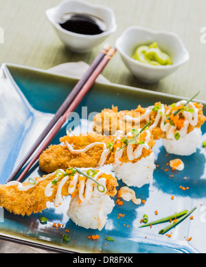 Thon ahi pané frit sur une boule de riz, arrosé de masago, mayonnaise et parsemé d'oignons verts et masago Banque D'Images