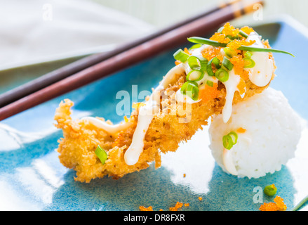 Thon ahi pané frit sur une boule de riz, arrosé de masago, mayonnaise et parsemé d'oignons verts et masago Banque D'Images