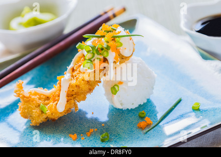 Thon ahi pané frit sur une boule de riz, arrosé de masago, mayonnaise et parsemé d'oignons verts et masago Banque D'Images