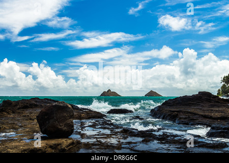 Vue de Na Mokulua islands, également connu sous le nom de Mokes et les jumeaux, d'une côte rocheuse dans Lanikai, Oahu, Hawaii Banque D'Images