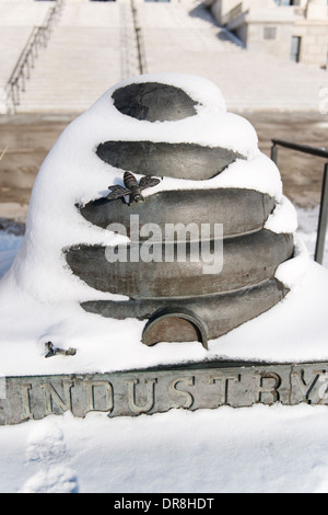 Statue de l'état de l'Utah, symbole de la ruche, représentant l'industrie, devant le bâtiment du Capitole et couvertes de neige. Banque D'Images