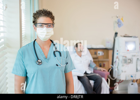 Infirmière en vêtements de protection pendant que le patient traités par dialyse Banque D'Images