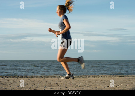 Une jeune femme fille courir la course à pied en compétition dans la course de 10k d'Aberystwyth, Décembre 2013 Banque D'Images