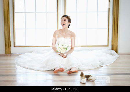 Une femme assise sur le sol avec robe de mariage sur Banque D'Images