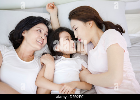 Une femme avec sa fille et petite fille sur un lit Banque D'Images