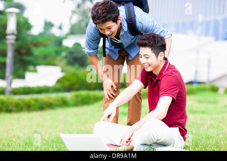 L'homme deux sur l'herbe laptop Banque D'Images