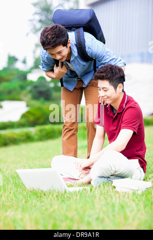 L'homme deux sur l'herbe laptop Banque D'Images