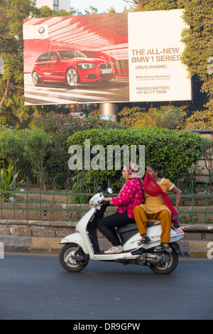 Une publicité pour les voitures BMW à Ahmedabad, Inde, contrastant avec les pauvres de la ville. Banque D'Images