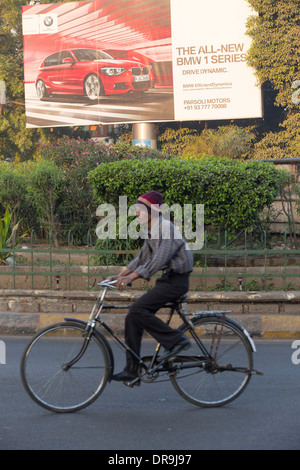 Une publicité pour les voitures BMW à Ahmedabad, Inde, contrastant avec les pauvres de la ville. Banque D'Images