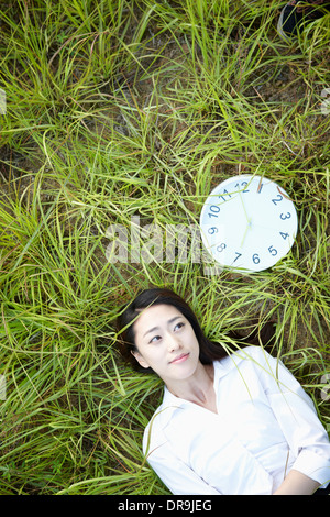 Une femme couchée sur l'herbe Banque D'Images