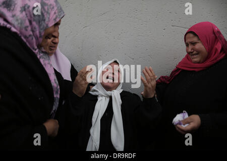 La bande de Gaza. 22 janvier, 2014. Des proches de militants palestiniens Ahmed Al-Za'anin pleurent lors de ses funérailles dans le nord de la bande de Gaza ville de Bit Hanoun le 22 janvier, 2014. Deux Jihad islamique (Guerre sainte) militants ont été tués tôt mercredi dans un raid aérien israélien dans le nord de la bande de Gaza, les membres du personnel et de la sécurité ont déclaré certaines sources. Credit : Wissam Nassar/Xinhua/Alamy Live News Banque D'Images