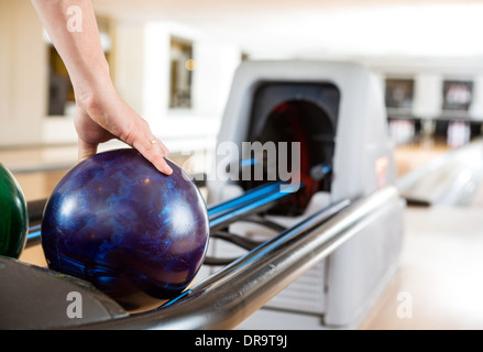 La main de l'homme Prendre Bowling Ball du rack Banque D'Images