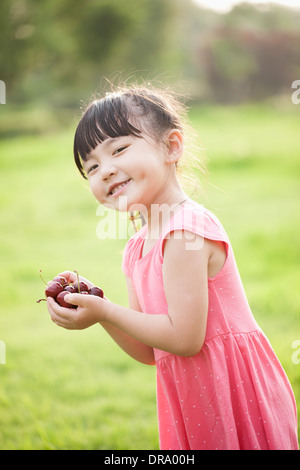 A girl holding a bouquet de cerises Banque D'Images