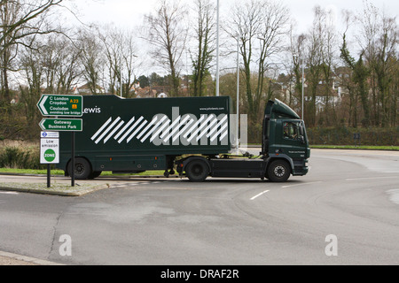 Un camion articulé John Lewis de la saisie d'un rond-point à Coulsdon, Surrey, Angleterre Banque D'Images