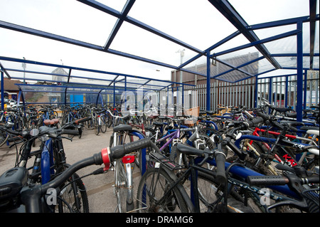 Les vélos garés en toute sécurité dans le parking à vélos sécurisé à l'extérieur d'une gare d'Angleterre. Banque D'Images