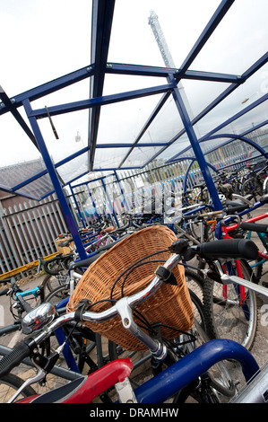 Les vélos garés en toute sécurité dans le parking à vélos sécurisé à l'extérieur d'une gare d'Angleterre. Banque D'Images