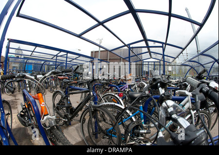 Les vélos garés en toute sécurité dans le parking à vélos sécurisé à l'extérieur d'une gare d'Angleterre. Banque D'Images