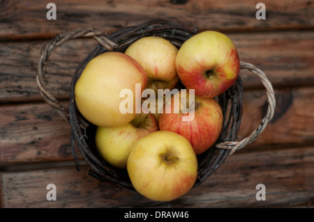 Un boisseau de pommes rouges dans un panier en bois rustique Banque D'Images