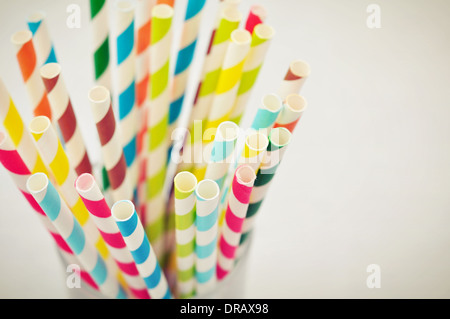 Pailles boire à rayures de couleurs différentes en verre sur fond clair Banque D'Images