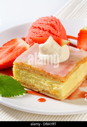 Crème anglaise (vanille) tranche avec les fraises fraîches et la crème glacée Banque D'Images