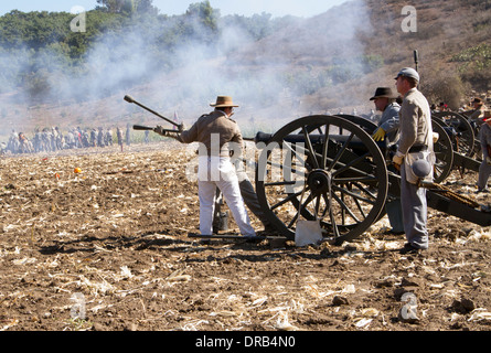 Les soldats confédérés, au cours d'une guerre civile américaine reconstitution d'un événement, le feu d'un canon sur le champ de bataille Banque D'Images