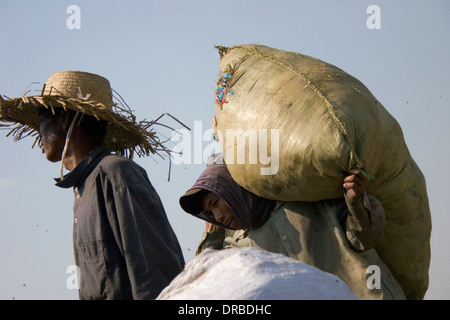 Un homme qui est une chasse travailleur est porteur d'une large sac à la décharge de Stung Meanchey toxiques à Phnom Penh, Cambodge. Banque D'Images