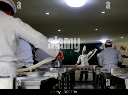 (140123) -- le 23 janvier, 2014 LANZHOU (Xinhua) -- les élèves à apprendre à s'étirer un bœuf et nouilles nouilles au centre de formation de cuisinier à Lanzhou, capitale de la province de Gansu, dans le nord-ouest de la Chine, le 22 janvier 2014. Avec une longue histoire de plus de 100 ans, datant de la dynastie Qing (1644-1912), bœuf et nouilles a gagné la renommée et à l'étranger. Il y a plus d'un millier de bœuf et nouilles restaurants à Lanzhou, qui vendent plus d'un million de parties de nouilles boeuf tous les jours. Pour les gens de Lanzhou, ce n'est pas seulement une tradition alimentaire, mais un mode de vie. (Xinhua/Liangkuai) Jin (zgp) Banque D'Images