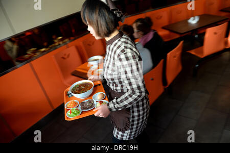 (140123) -- le 23 janvier, 2014 LANZHOU (Xinhua) -- une serveuse sert des nouilles boeuf nouilles dans un restaurant à Lanzhou, capitale de la province de Gansu, dans le nord-ouest de la Chine, 22 janvier 2014. Avec une longue histoire de plus de 100 ans, datant de la dynastie Qing (1644-1912), bœuf et nouilles a gagné la renommée et à l'étranger. Il y a plus d'un millier de bœuf et nouilles restaurants à Lanzhou, qui vendent plus d'un million de parties de nouilles boeuf tous les jours. Pour les gens de Lanzhou, ce n'est pas seulement une tradition alimentaire, mais un mode de vie. (Xinhua/Liangkuai) Jin (zgp) Banque D'Images