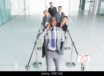 Businessman talking on cell phone in line Banque D'Images