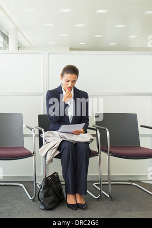 Businesswoman reading dans l'aire d'attente Banque D'Images