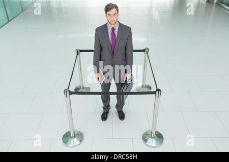 Businessman standing in roped-off square Banque D'Images