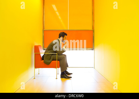 Businessman thinking in bright office Banque D'Images