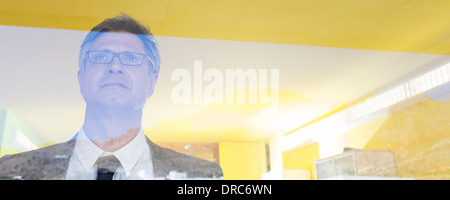 Businessman standing at office window Banque D'Images