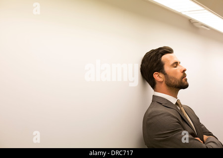 Woman with eyes closed leaning against wall Banque D'Images