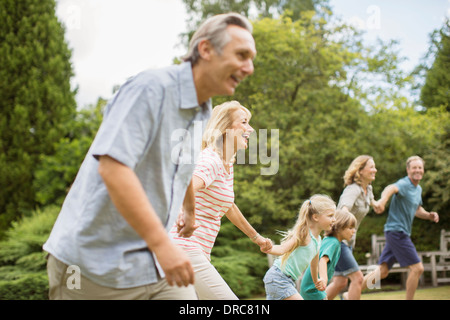 Multi-generation family holding hands and running Banque D'Images