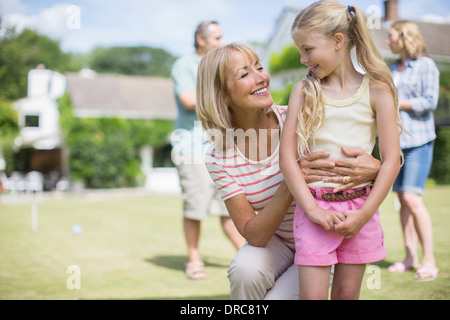 Grand-mère hugging granddaughter outdoors Banque D'Images