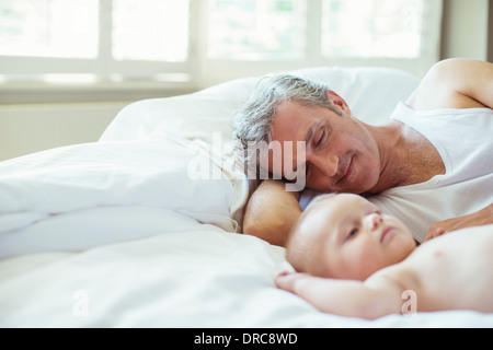 Father and baby laying on bed Banque D'Images