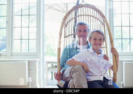 Père et fils assis dans wicker chair Banque D'Images